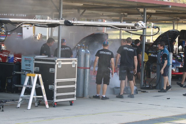 Triple Eight crew members assess the damage following a small fire on Craig Lowndes' Commodore pic: Matthew Paul Photography